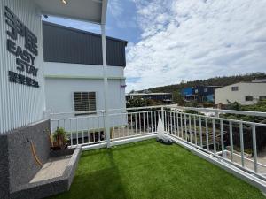 a balcony with green grass next to a building at Easy Stay Club in Xiaoliuqiu