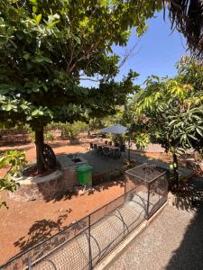 un parc avec une clôture, un arbre et des tables dans l'établissement Parnakuti Cottage, à Trimbak