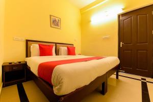Un dormitorio con una cama grande con almohadas rojas. en Super Hotel O Diamond In, en Kochi