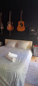 a bedroom with a bed with guitars on the wall at La suite musicale in Villeneuve-Saint-Denis