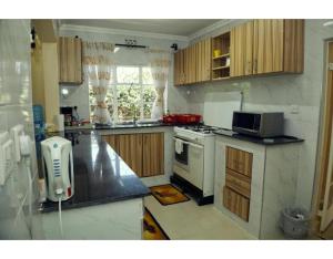 a kitchen with a stove and a microwave at Spacious Town House in Nakuru in Nakuru