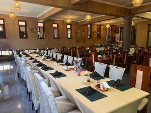 a long table in a room with tables and chairs at Lush Garden Hostel in Arusha
