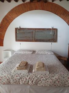 a bedroom with a bed with a wooden headboard at Agriturismo La Creta in Montepulciano