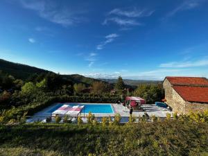 a swimming pool next to a building and a house at La Cascina Langa in Ponti
