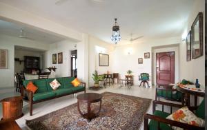 ein Wohnzimmer mit einer grünen Couch und einem Tisch in der Unterkunft Luxurious BnB next to Corporate hubs in Jāmb