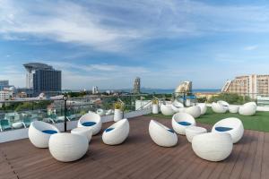 a group of white chairs sitting on a roof at Blue Boat Hotel JC in Pattaya North