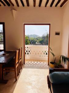 a dining room with a table and a large window at Two Bedroom Private Apartment in Shela, Lamu in Shela +14 photos
