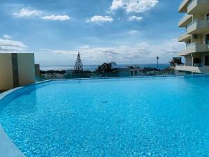 a large blue swimming pool on top of a building at Luxury Seaview Apartment in Palmyre