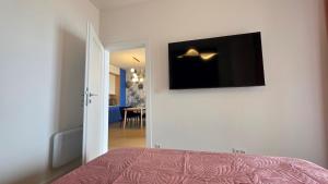 a bedroom with a bed and a flat screen tv on the wall at Boszkowo Horizon Park Apartament 21 "Lazurowy" in Boszkowo +12 photos
