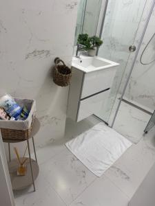 a white bathroom with a sink and a shower at ABE Apartment in Craiova +28 photos