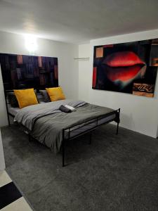 a bedroom with a bed with a painting on the wall at Hidden Putney-Studio Flat in London