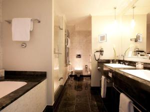 a bathroom with two sinks and a tub and a toilet at Fairmont Le Montreux Palace in Montreux