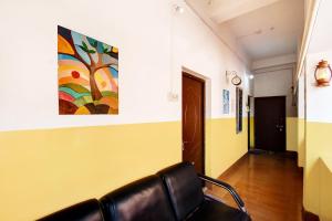 a chair in a hallway with a painting on the wall at Hotel O Adorini Guest House in Shānti Niketan