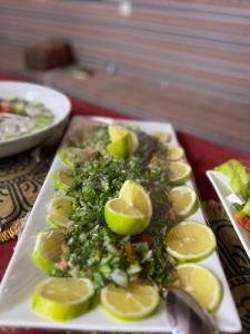 Gakleen luxury camp في العقبة: طبق من الخضرا وشرائح الليمون على الطاولة +81 صورة