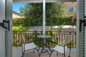 a patio with a table and chairs on a balcony at Arolithos in Spetses