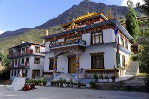 a large white building in front of a mountain at Kyelang Times in Kyelang