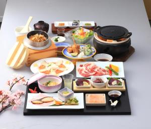 una mesa cubierta con diferentes tipos de comida en platos en 宿毛リゾート椰子の湯, en Sukumo