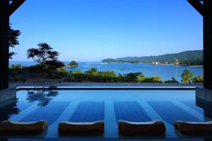 una piscina con vista al agua en 宿毛リゾート椰子の湯, en Sukumo