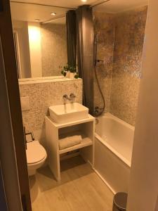 Un baño con lavabo, inodoro y bañera. en Scenic fully equipped studio, en Planvillard