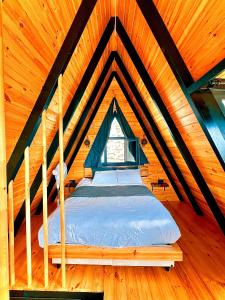 a bed in a wooden room with a window at Mirana Bungalov in Ardeşen +29 photos