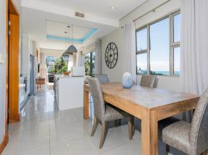 a kitchen and dining room with a wooden table and chairs at Eden Palms , Ballito in Shakaʼs Rock
