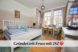 a bedroom with a bed and a dining room at 12 FEWOs im Jugendstilhaus mit Aufzug, Terrasse, Kingsize-Bett, Smart-TV, etc in Erfurt