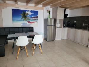 a kitchen with a dining table and white chairs at Vonitsa Loft Apartment 1 in Vonitsa