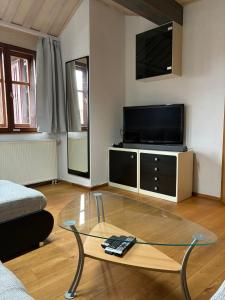ein Wohnzimmer mit Fernseher und Couchtisch in der Unterkunft Ferienwohnung Monteurswohnung für 1 bis 8 Personen in Diebach + 16 Fotos