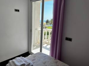 a bedroom with a bed and a window with purple curtains at Mirador mar in L'Ametlla de Mar