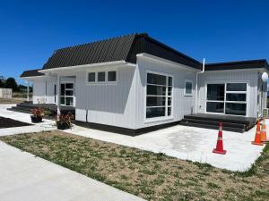 a small white house with an orange cone in front of it at Greytown Martinborough mansion in Greytown