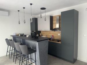 a kitchen with a black counter and bar stools at Vila AS Krimovica in Krimovice
