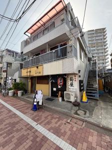 un bâtiment dans une rue avec des cônes de signalisation devant lui dans l'établissement Vacation Inn Haneda 1, à Tokyo