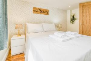 a bedroom with a white bed with two towels on it at Superb City Center 2 Bed Apartment Free Wifi in Lincoln