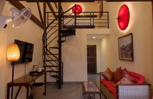 a living room with a spiral staircase and a couch at Rikitikitavi in Kampot