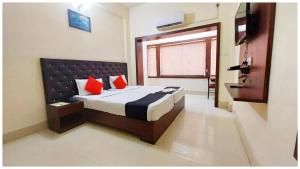una camera con un letto con due cuscini rossi di Hotel Bhagwat Near Temple a Bhubaneshwar