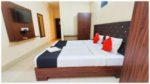 una camera da letto con un letto grande con cuscini rossi di Hotel Bhagwat Near Temple a Bhubaneshwar