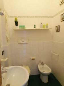 a white bathroom with a sink and a toilet at Sicily & Sun Letojanni Taormina in Letojanni