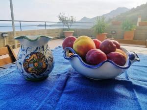 a bowl of fruit on a table with a vase at Sicily & Sun Letojanni Taormina in Letojanni +45 photos