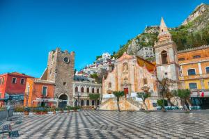a group of buildings with a mountain in the background at Sicily & Sun Letojanni Taormina in Letojanni