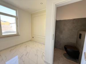 a bathroom with a toilet and a window at Haus Deitje in Borkum