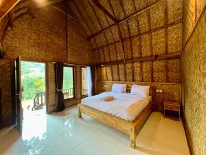 a bedroom with a bed in a straw hut at Azhani Bungalow in Tetebatu