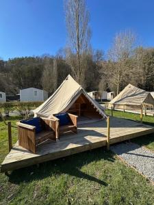 a yurt with chairs and a table on a wooden deck at bell tent in Durbuy