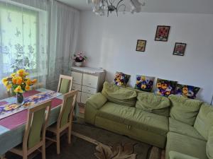 a living room with a green couch and a table at Apartament Lidka Zaprasza in Kwidzyn