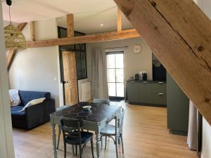 a kitchen and dining room with a table and chairs at La ferme des peupliers in Estaires