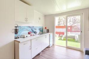 a kitchen with white cabinets and a large window at Flor de Loto Tantralove in Aguatona