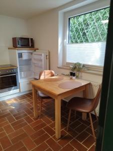 a kitchen with a wooden table and two chairs at Moderne Ferienwohnung mit privatem Eingang - ROSA in Kalletal +9 photos