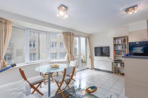 Una cocina y una sala de estar con mesa y sillas. en Gilles 124, en Ostende