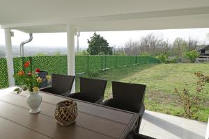a table with chairs and a vase of flowers on a patio at Villa Perla in Despotovac