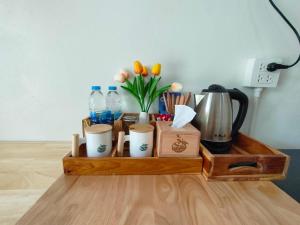 a wooden tray with cups and flowers and water at Suanthara kokut in Ko Kood