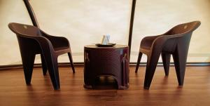 a group of three chairs with a table in between them at Cocoon Creek in Kodaikānāl